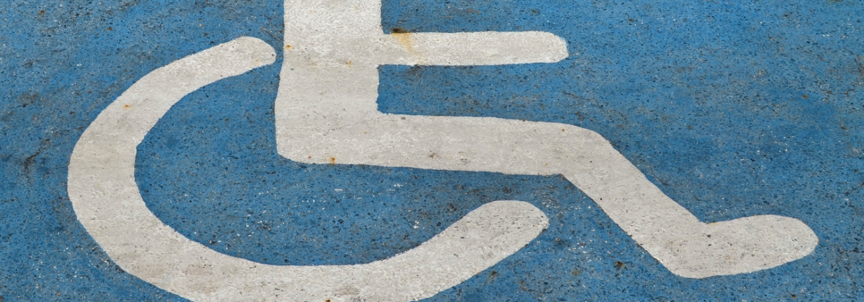 Handicapped or disabled parking sign on blue asphalt