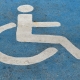 Handicapped or disabled parking sign on blue asphalt